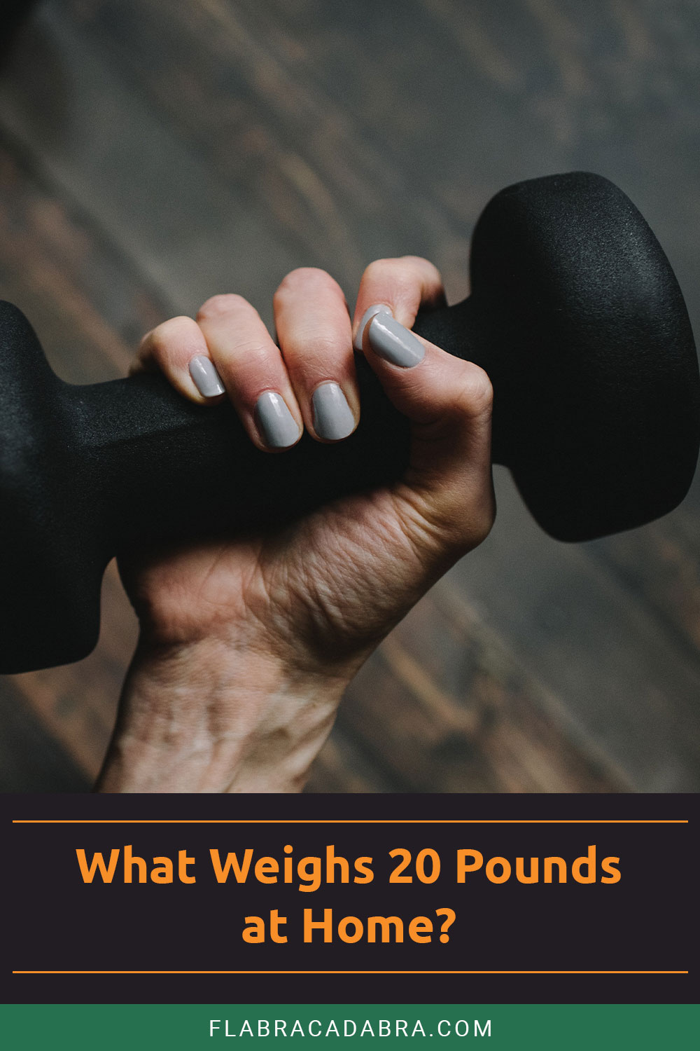A black dumbbell in a hand with grey nail polish - What Weighs 20 Pounds at Home?